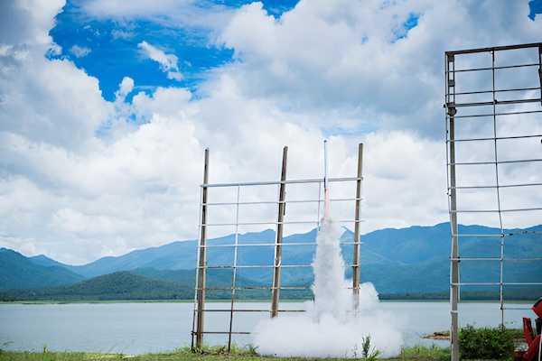 Rocket taking off from a handmade bamboo launcher during the Bun Bang Fai Rocket Festival in Thailand