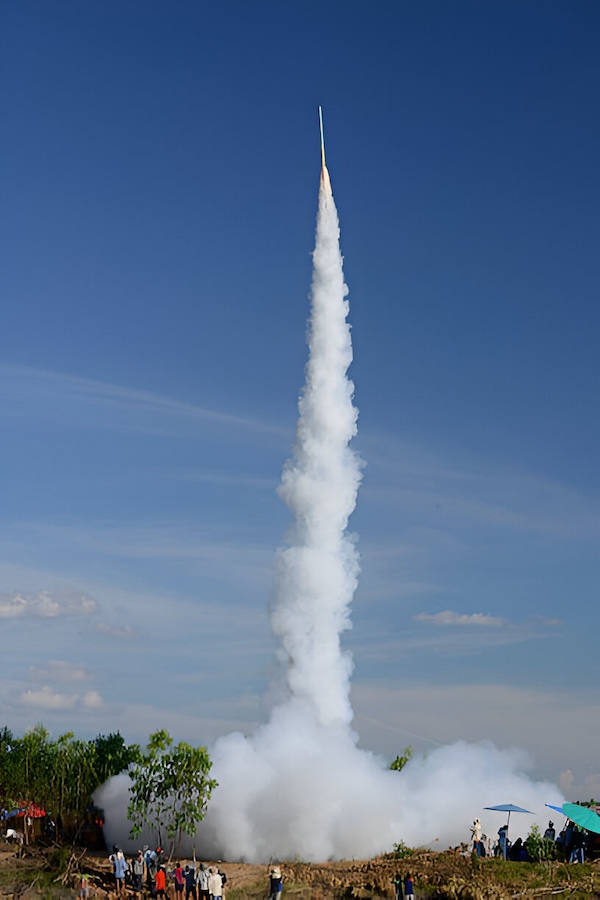 Handmade rocket launching high into the blue sky during the Bun Bang Fai Rocket Festival in Thailand