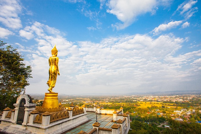 Golden Buddha statue at Wat Phra That Khao Noi overlooking Nan province — a serene spot to experience the beauty of Thailand in summer