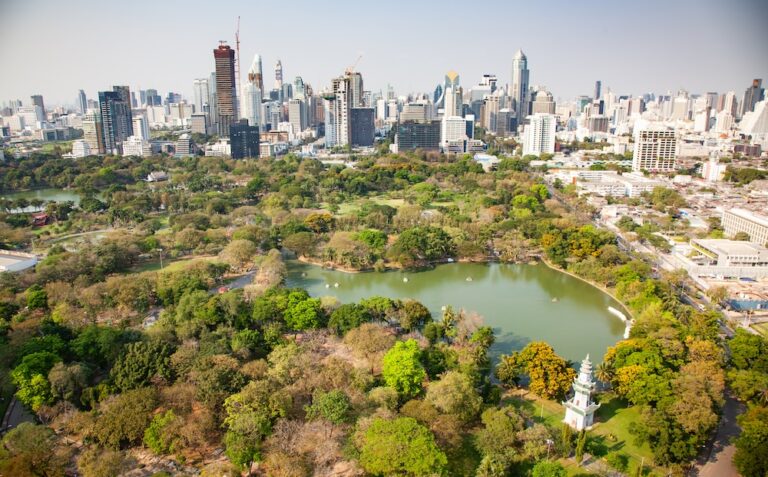 Aerial view of Lumphini Park in Bangkok surrounded by skyscrapers