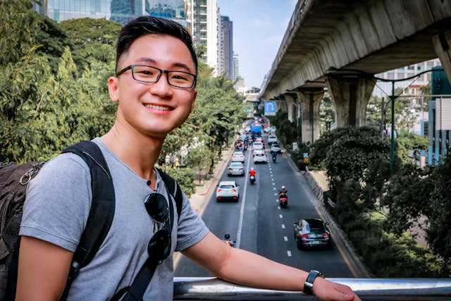 Happy tourist in Bangkok standing above a busy street – a reminder that staying informed helps enjoy Thailand safely
