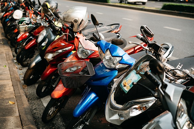Row of colorful scooters parked on a city sidewalk in Thailand