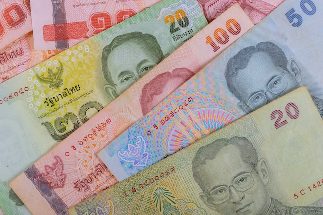 Close-up of Thai baht banknotes, often involved in currency exchange scams and shortchanging tricks targeting tourists