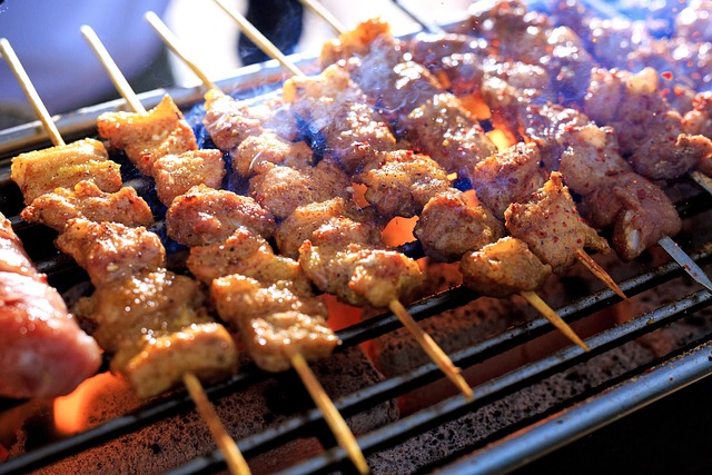 Thai Moo Ping skewers grilling over hot charcoal flames