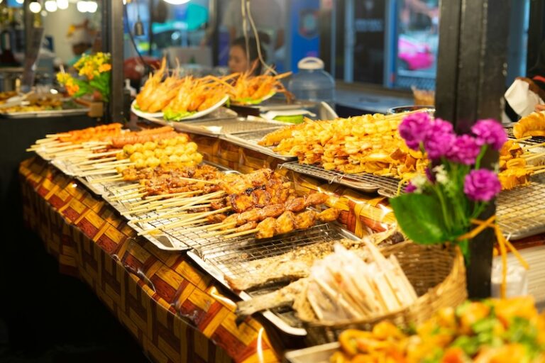 Various Thai grilled skewers displayed at a night market food stall