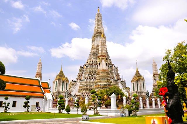 Central prang and colorful spires of Wat Arun, the Temple of Dawn, Bangkok, Thailand, under a blue sky