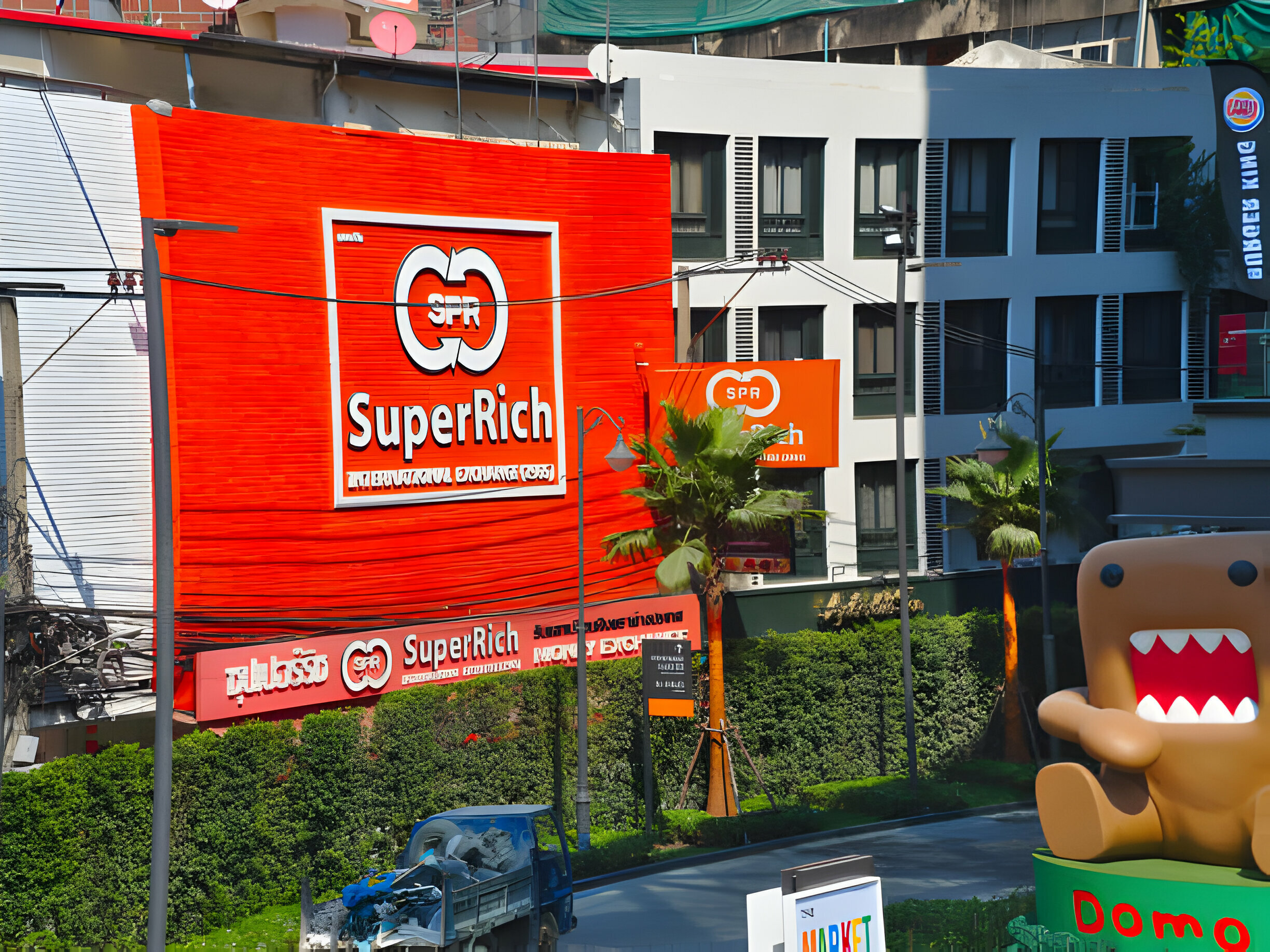 Façade d'un bureau de change SuperRich 1965 à Bangkok, avec son enseigne orange distinctive et la mention "International Exchange".