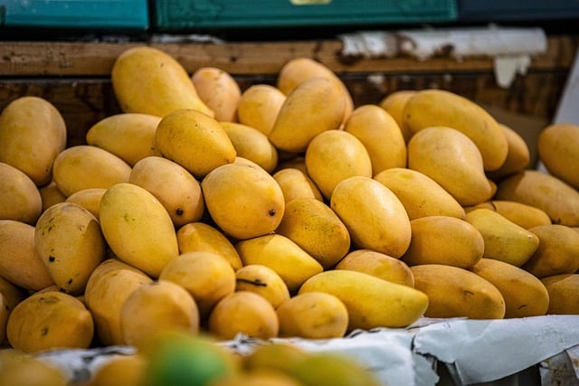 Pile de mangues mûres exposées sur un marché.
