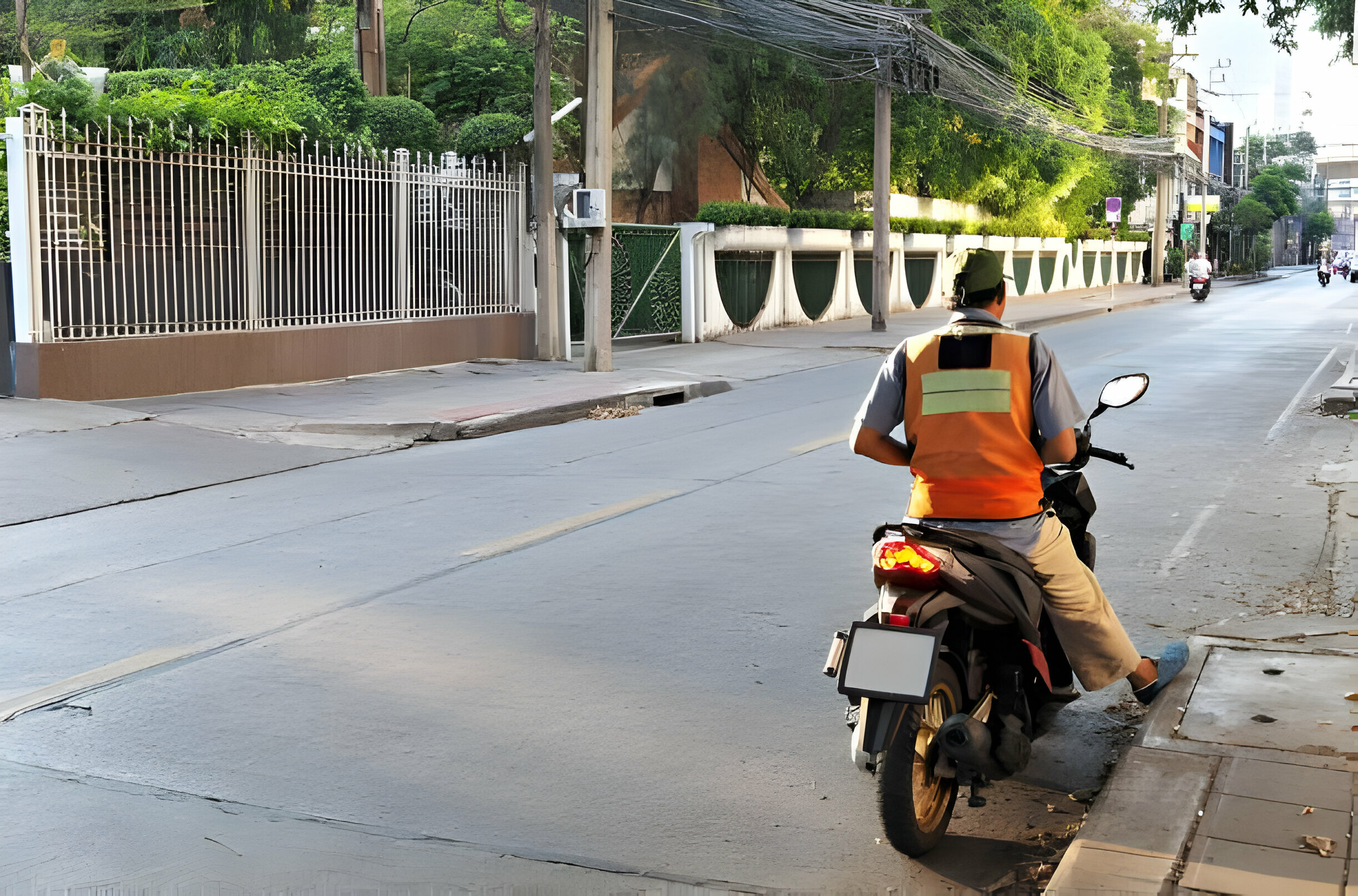 Moto taxi avec un gilet réfléchissant se préparant à démarrer sur une route de ville.