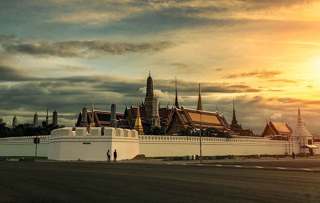 Le palais royal au coucher du soleil à Bangkok, Thaïlande, avec des visiteurs au premier plan.