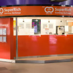 Bureau de change de devises SuperRich de couleur orange dans un espace commercial.