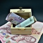 Billets de baht thaïlandais dans une petite boîte en bois ouverte.