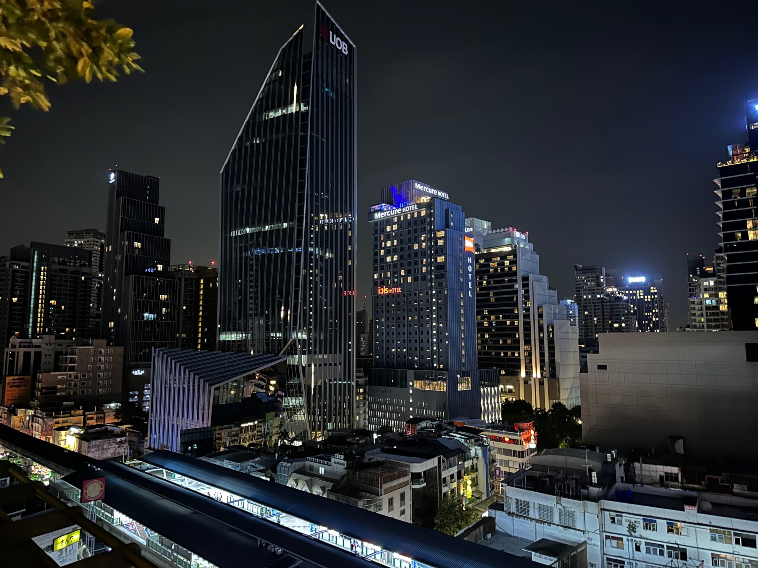 Vue nocturne des gratte-ciels illuminés vus depuis le Mall EmQuartier à Bangkok.