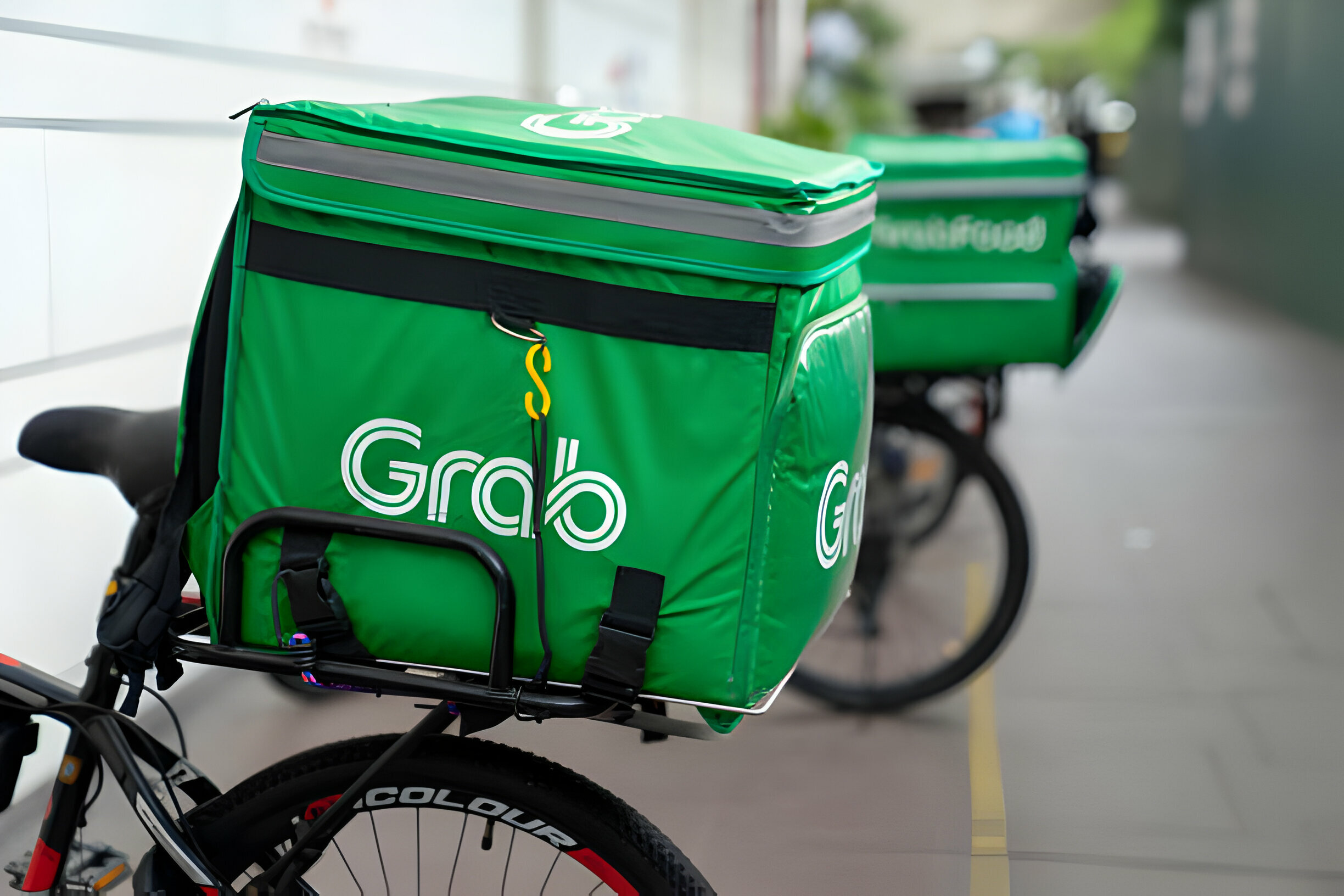 Sacs de livraison Grab verts fixés sur des vélos en stationnement