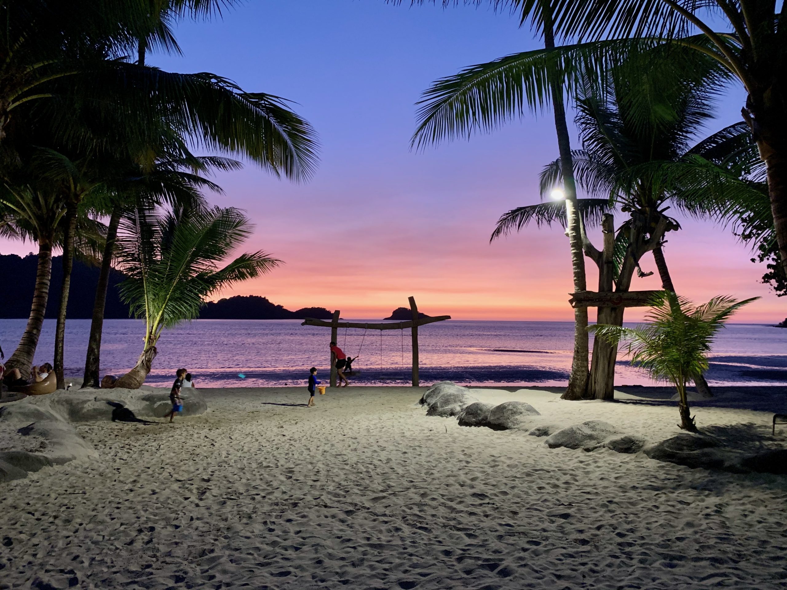 Coucher de soleil captivant sur la plage de Ko Chang avec silhouettes et palmiers