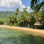 Vue paisible d'une plage de Koh Chang avec des huttes et des palmiers