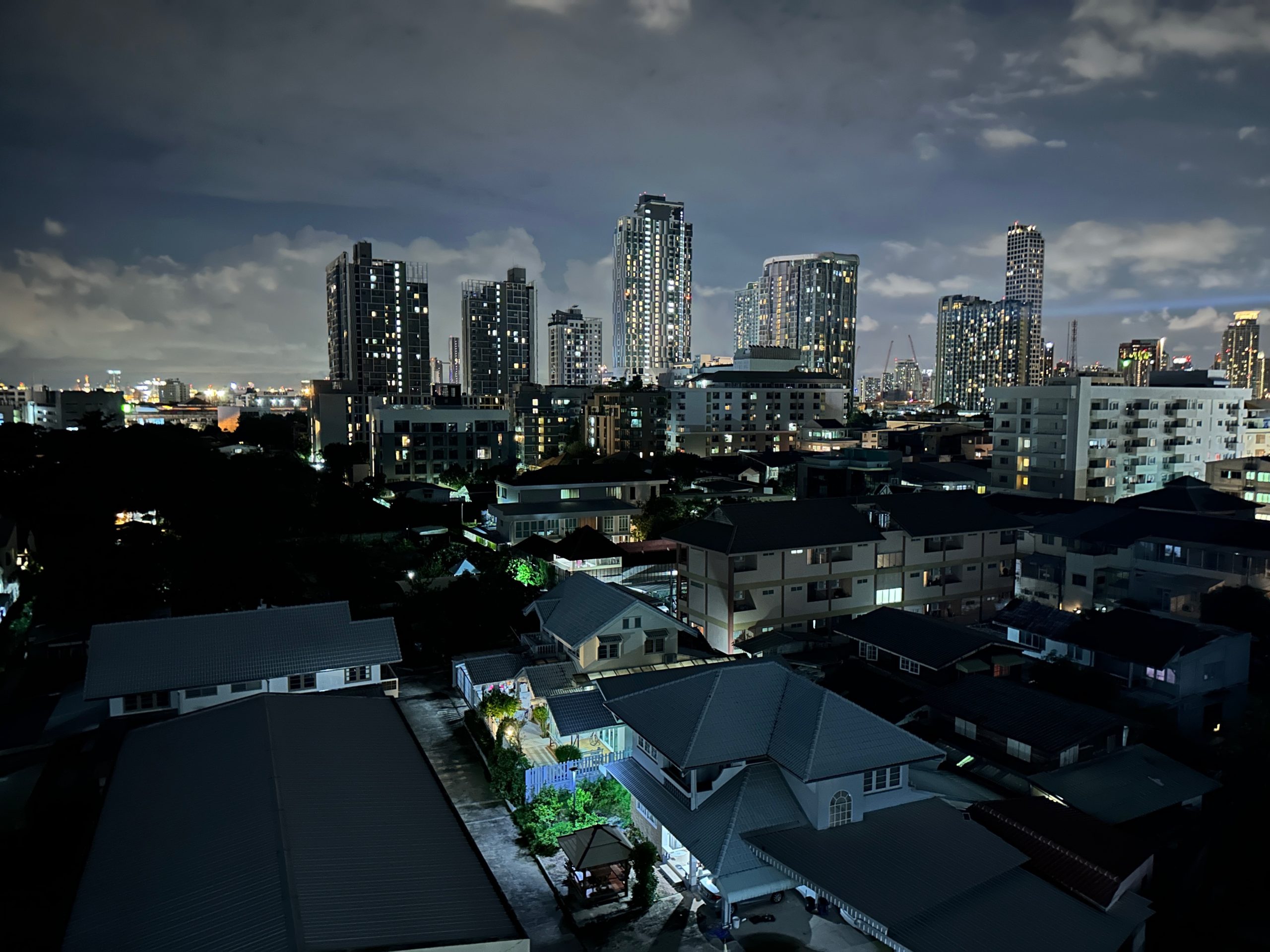 Vue de nuit sur le quartier On Nut à Bangkok avec des immeubles résidentiels éclairés.