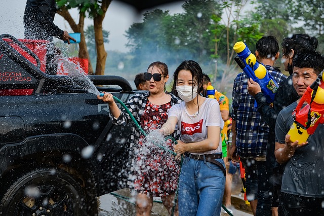 Foule célébrant Songkran en Thaïlande avec des pistolets à eau et des seaux