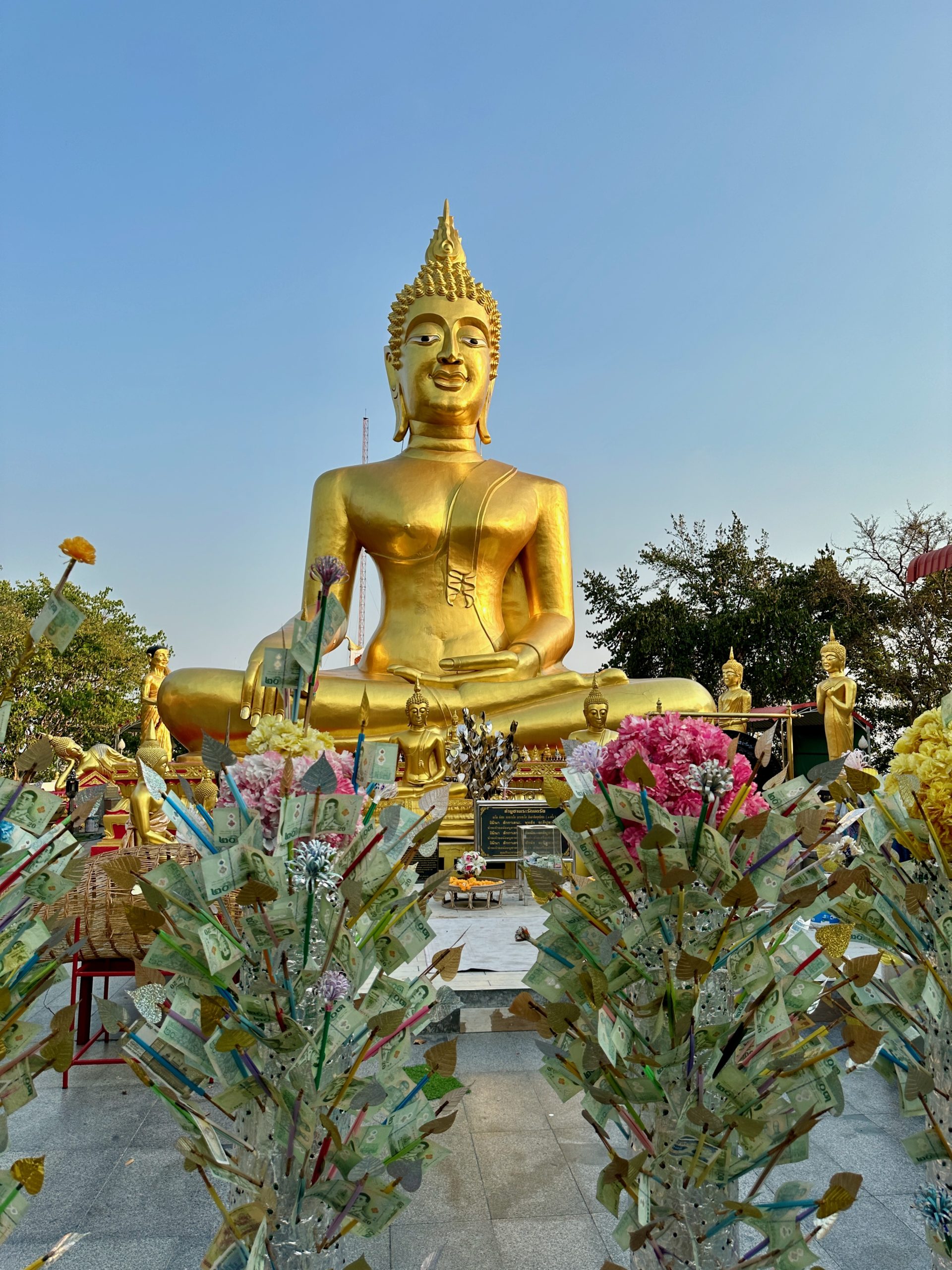 Statue dorée du Big Buddha à Pattaya avec des offrandes en argent.