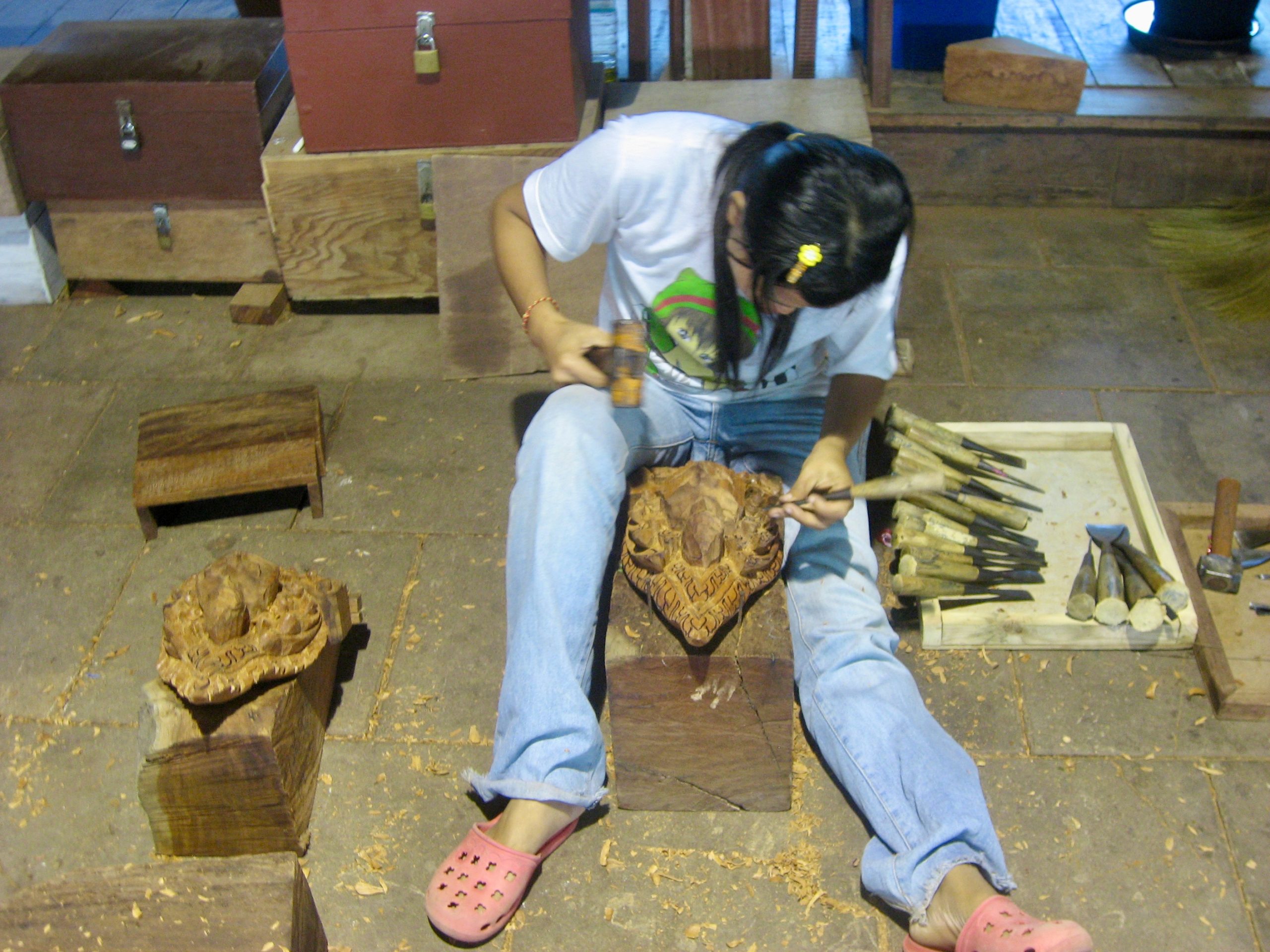 Artisan sculptant le bois au Sanctuaire de la Vérité à Pattaya.