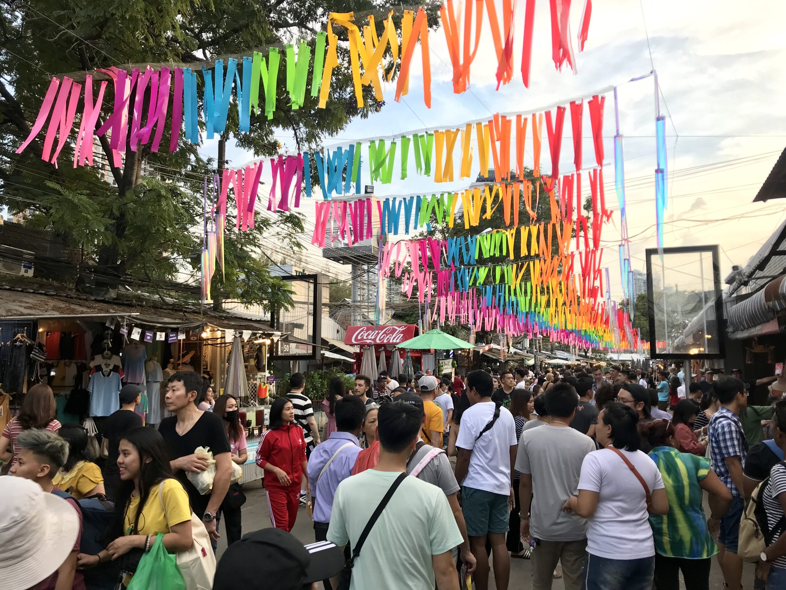 Shopping en Thaïlande au marché de Chatuchak, entre stands d’artisanat, vêtements et une ambiance locale vibrante.