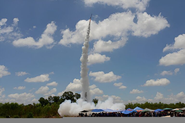 Fusée artisanale s'envolant sous un ciel bleu pendant le festival Bun Bang Fai en Thaïlande