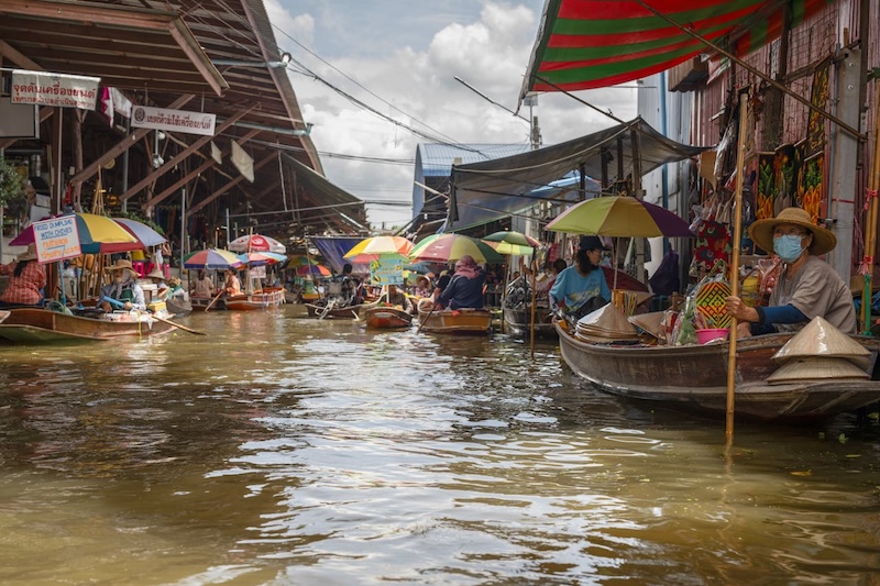 Vue animée d’un marché flottant en Thaïlande avec vendeurs et barques