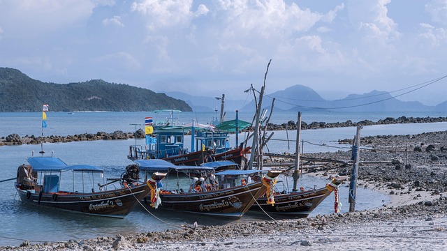 Bateaux longtails décorés de rubans colorés, amarrés près d’un village de pêcheurs à Koh Samui, avec vue sur les îles du golfe