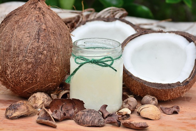 Pot d’huile de coco artisanale entouré de noix de coco entières et ouvertes en Thaïlande