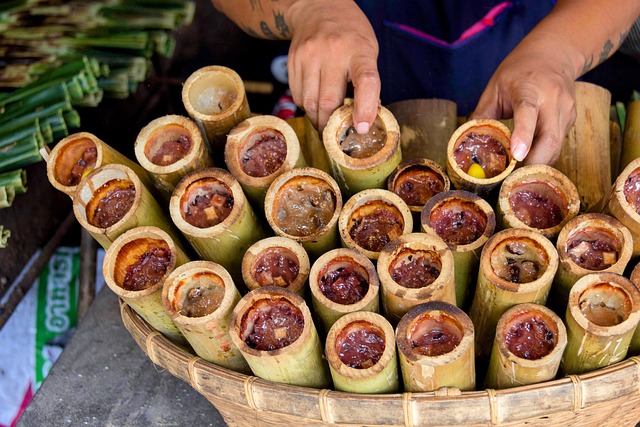 Khao Lam, un dessert thaïlandais traditionnel de riz gluant sucré cuit à l'intérieur de tronçons de bambou, présenté dans un panier sur un marché.