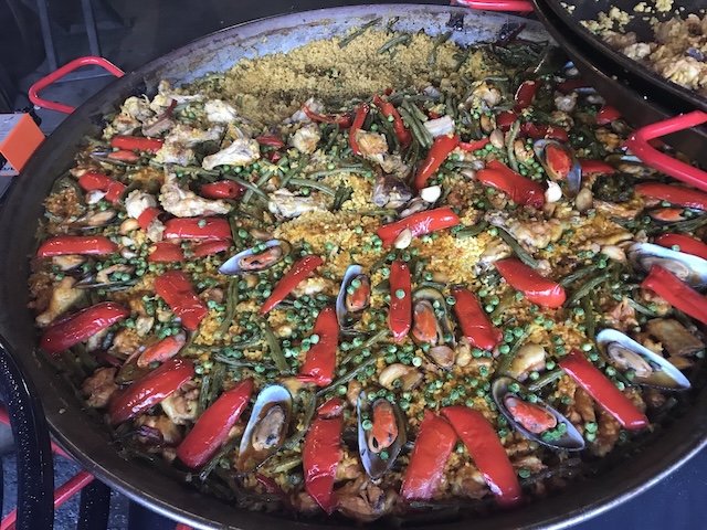 Plat de paella géante cuite sur place au marché de Chatuchak, avec fruits de mer, poivrons rouges et petits pois
