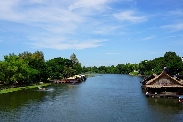 La rivière Kwaï bordée de végétation et de maisons flottantes traditionnelles, Thaïlande