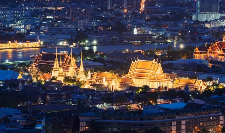 Vue nocturne sur le Wat Pho et le Grand Palais à Bangkok, temples illuminés au bord du fleuve
