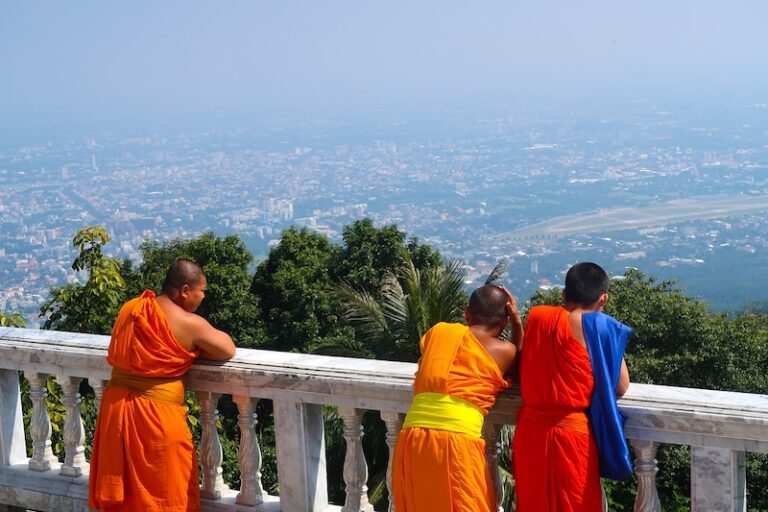 Jeunes moines en habits orange observant Chiang Mai depuis les hauteurs du Doi Suthep