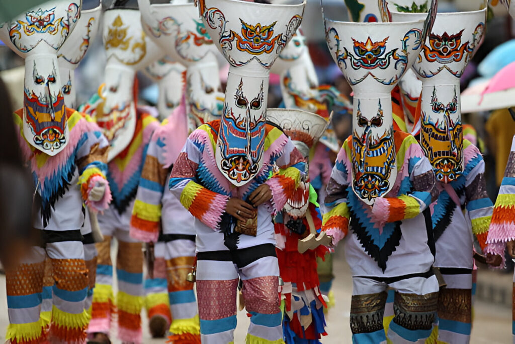 Participants au festival Phi Ta Khon en Thaïlande, portant les masques traditionnels et des costumes très colorés.