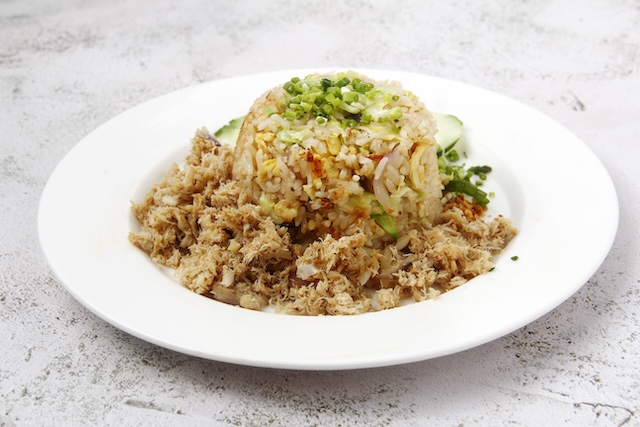 Assiette de Khao Pad Poo, riz frit au crabe thaïlandais avec œuf, légumes et ciboulette
