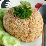Assiette de Khao Pad thaïlandais avec œuf, carottes, riz frit et tranches de concombre