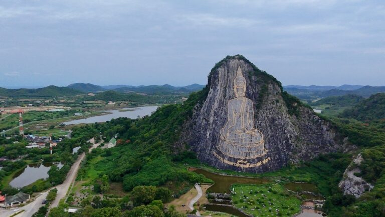Gravure géante du Bouddha sur la falaise de Khao Chi Chan entourée de verdure près de Pattaya, Thaïlande