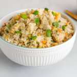 Bol de riz frit thaïlandais au poulet, carottes, œufs brouillés et oignons verts