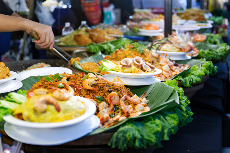 Stand de street food en Thaïlande avec nouilles sautées, crevettes et calamars servis sur feuilles de bananier