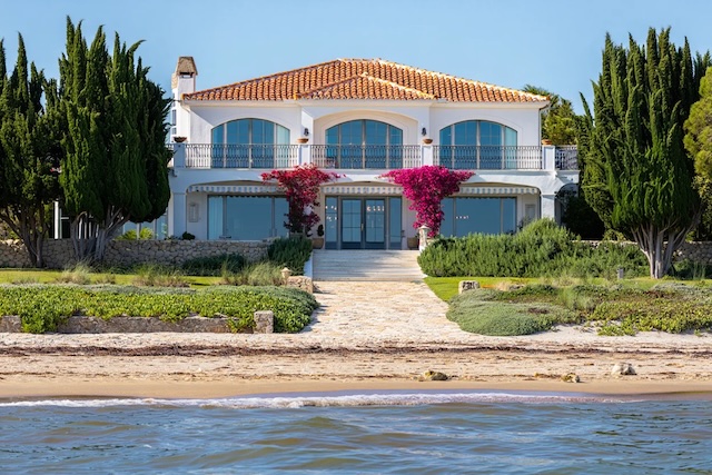Grande villa de luxe blanche avec toit en tuiles, bougainvilliers et accès direct à la plage