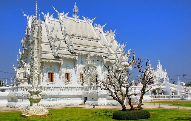Vue latérale du Temple Blanc Wat Rong Khun à Chiang Rai, mettant en valeur ses ornements et sa blancheur éclatante