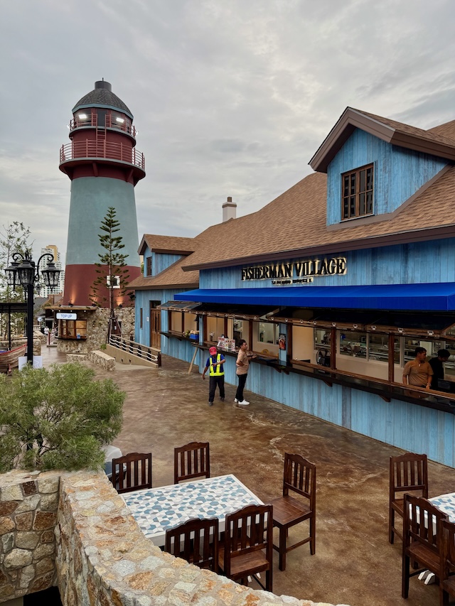 Vue de l'esplanade du Fisherman Village à Pattaya, avec le phare emblématique, les restaurants au style scandinave et les terrasses pour manger en plein air.