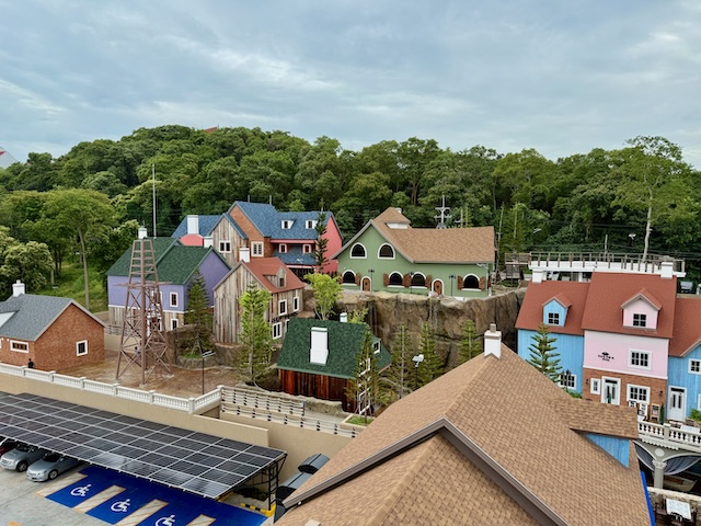 Vue d'ensemble sur l'architecture colorée et le style scandinave des bâtiments du Fisherman Village à Pattaya, adossés à la colline verdoyante de Pratumnak.