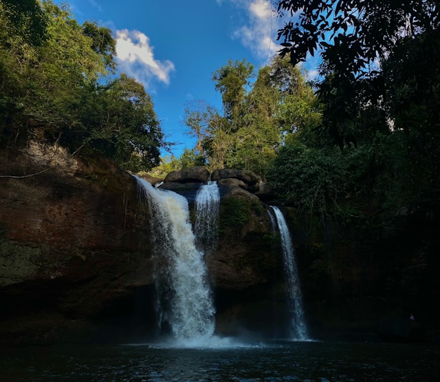 La cascade Haew Suwat dans le parc national de Khao Yai, avec l'eau tombant de rochers dans un bassin entouré par la jungle luxuriante.