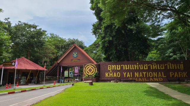 Portail d'entrée du Parc National de Khao Yai avec le grand panneau en bois indiquant le nom du parc en thaï et en anglais et le poste de contrôle des billets.