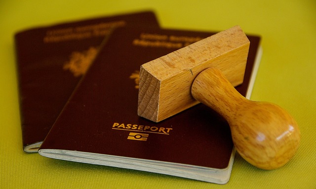 Un tampon en bois posé sur des passeports biométriques, illustrant les démarches administratives pour obtenir un visa pour la Thaïlande.