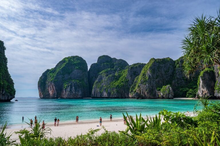 Vue de la célèbre plage de Maya Bay à Koh Phi Phi, avec son sable blanc, son eau turquoise et ses imposantes falaises karstiques verdoyantes.