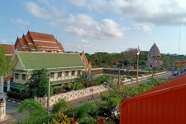 Vue d'un complexe de temples dans la province de Buriram en Thaïlande, montrant un temple de style khmer en pierre à droite et un bâtiment de style thaïlandais à gauche.