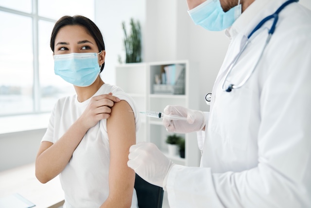Une voyageuse reçoit un vaccin dans le bras, une étape essentielle pour la santé avant de partir en Thailande.